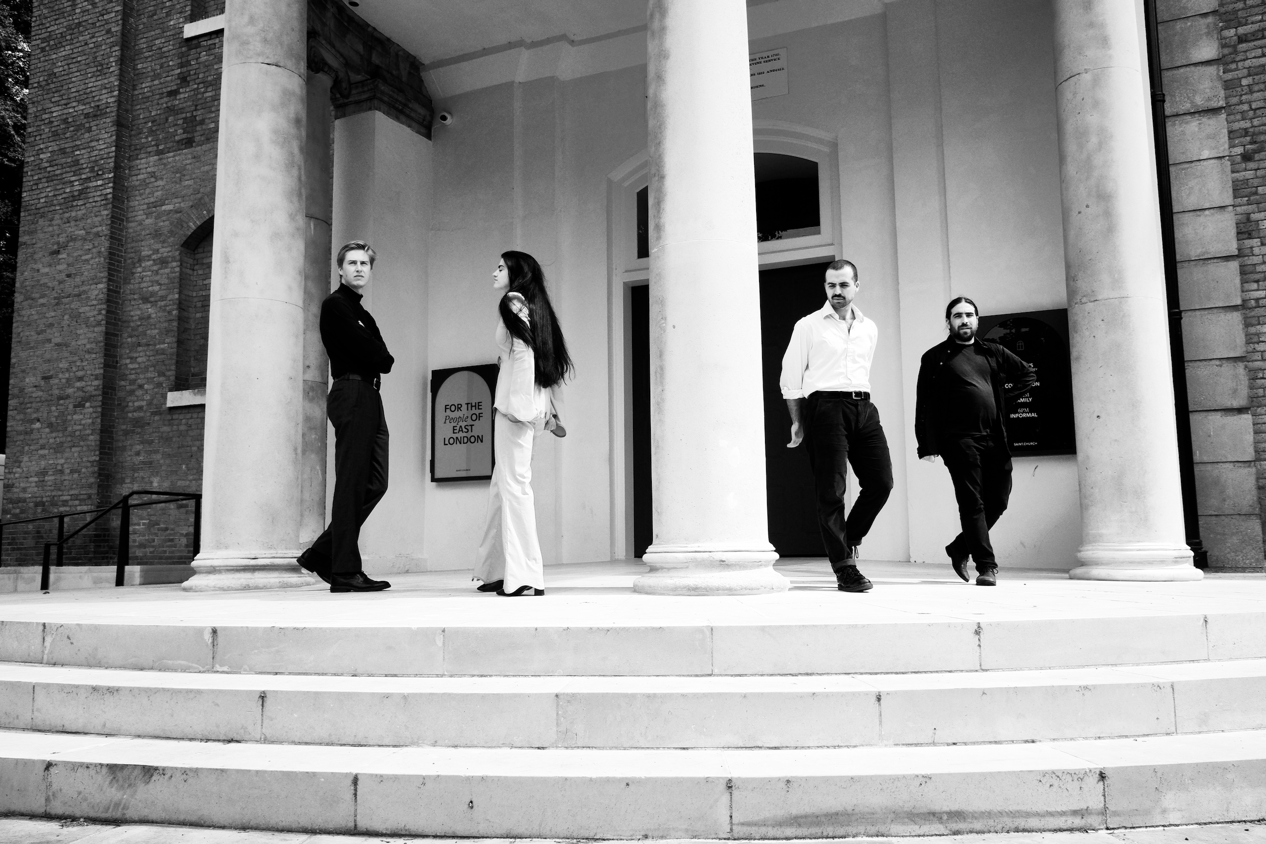 The four members of Modern Woman in front of an East London public building, in black and white