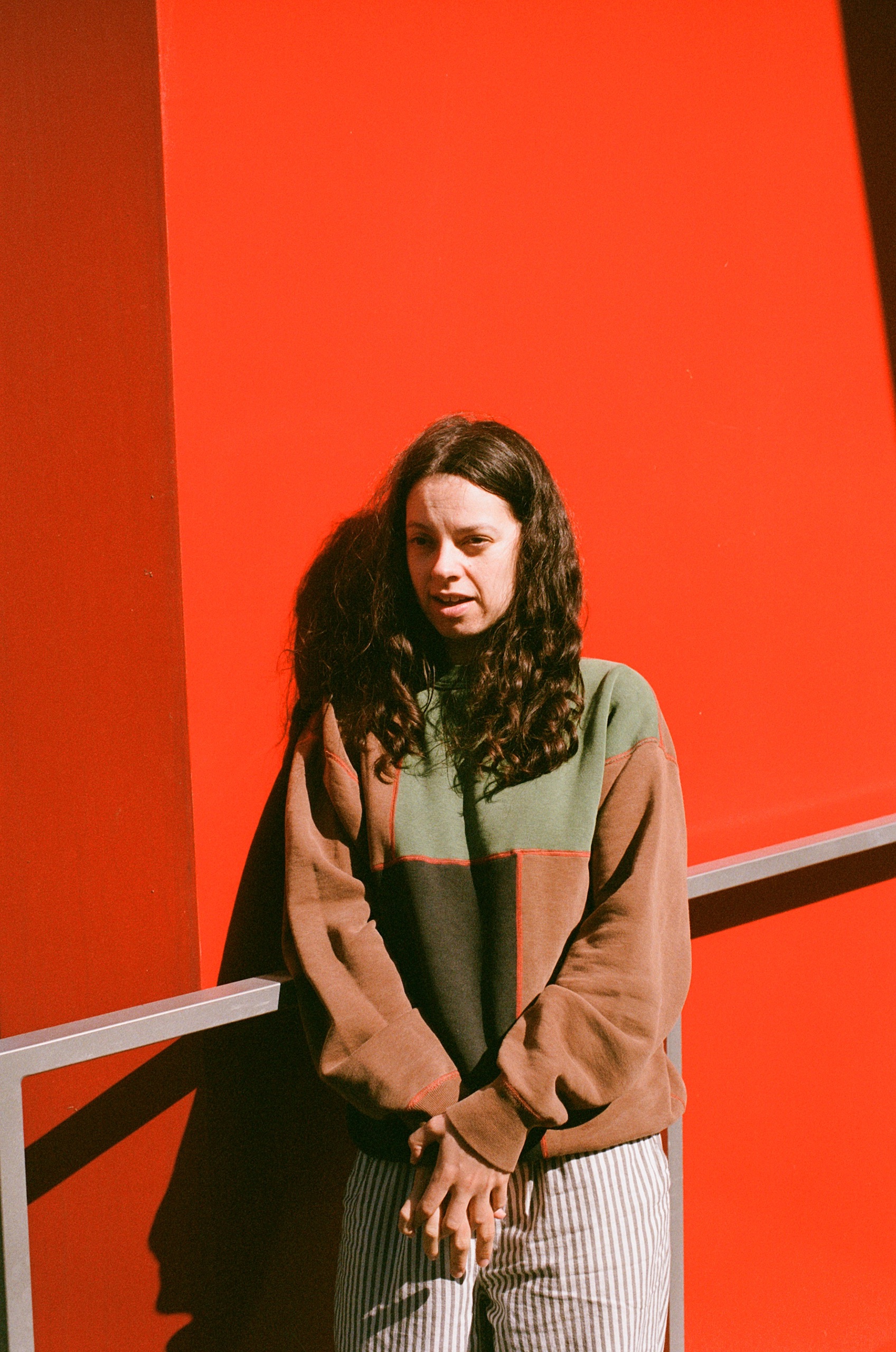 Tirzah – artist stood against orange wall