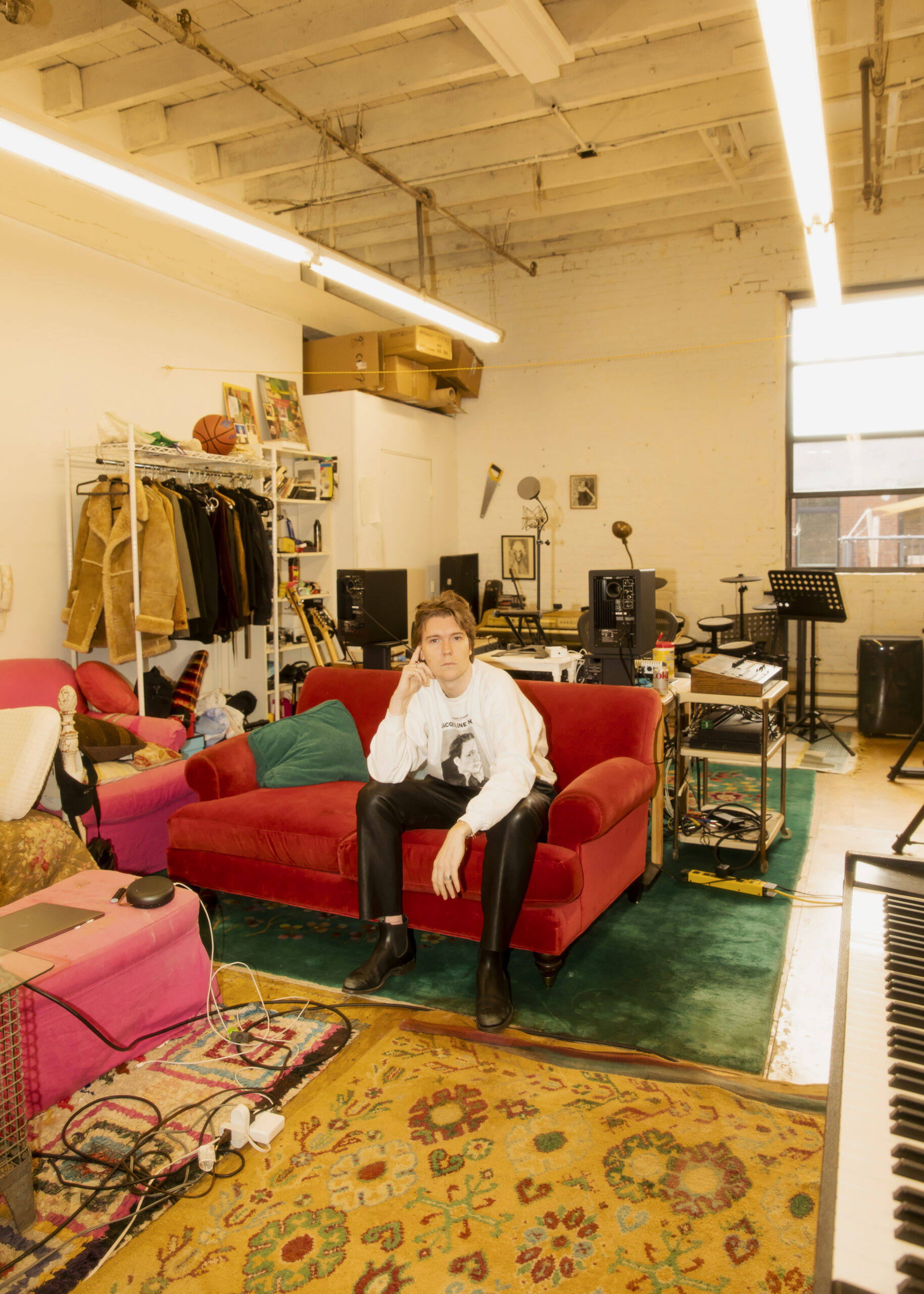 Alex Cameron sat on a sofa in the middle of his Brooklyn warehouse studio
