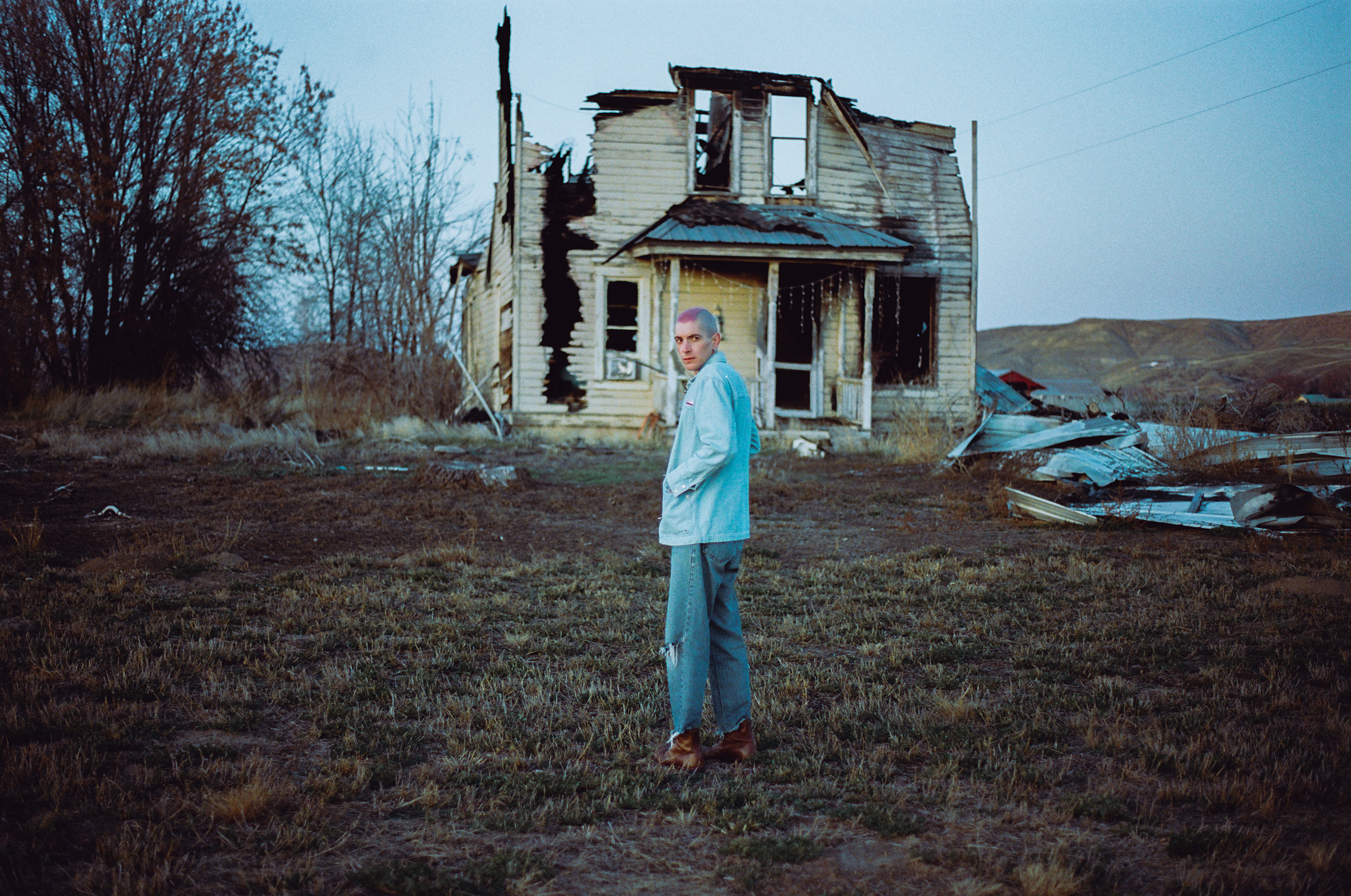 Youth Lagoon stood in front of a derelict house